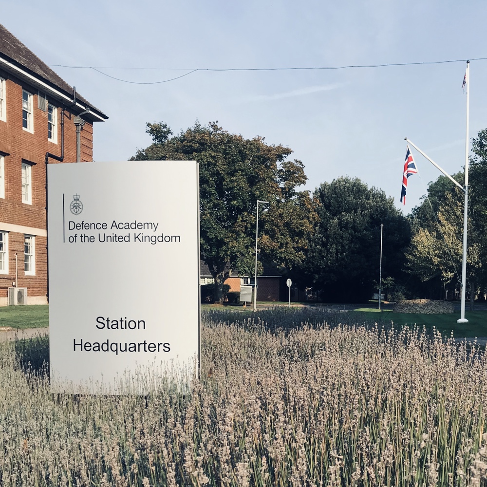Outside Headquarters building showing signage with lavender in the foreground